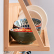 Side on view of our kitchen plate rack with bowels and plates being displayed. The detail of the wood is on show. 